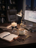Midnight Roastery coffee-inspired soy candle on a workspace desk beside a warm cup of coffee, notebook, keyboard, and desk lamp. Designed to create a cozy atmosphere for late-night work, writing, studying, and creative focus.