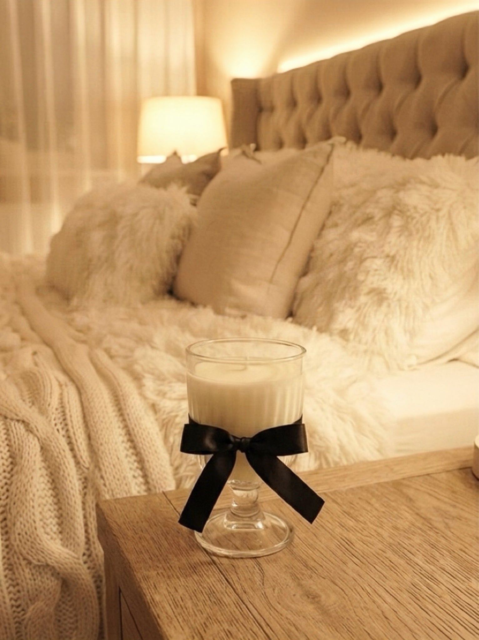 Fluffy Cloud soft woody soy candle styled in a cozy bedroom with warm lighting and elegant home decor.